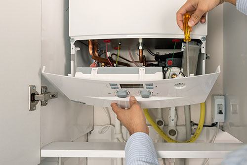 Heating technician repairing a residential boiler in Temple City