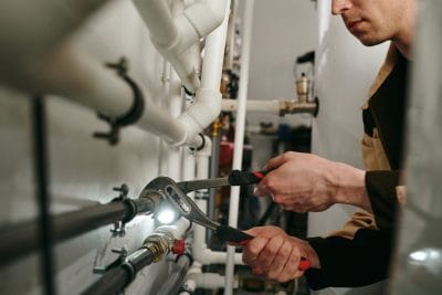 Technician inspecting commercial plumbing pipes in Temple City