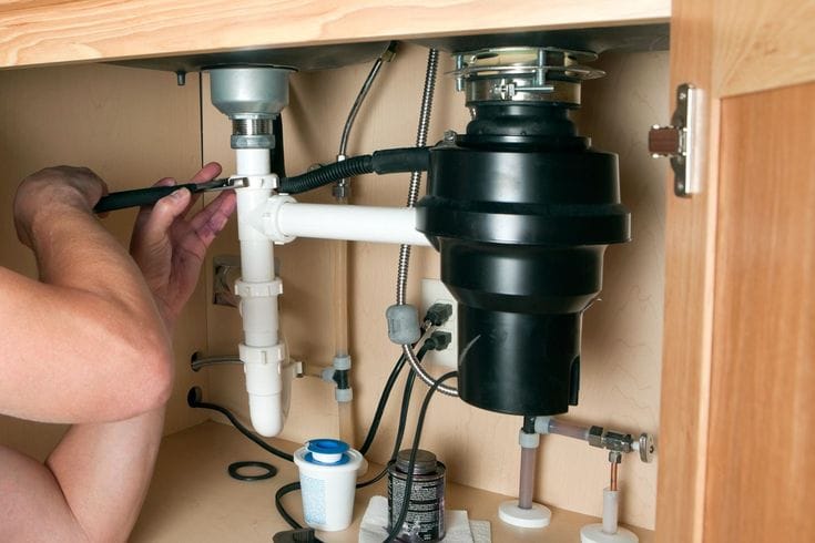 Plumber repairing a garbage disposal in Temple City