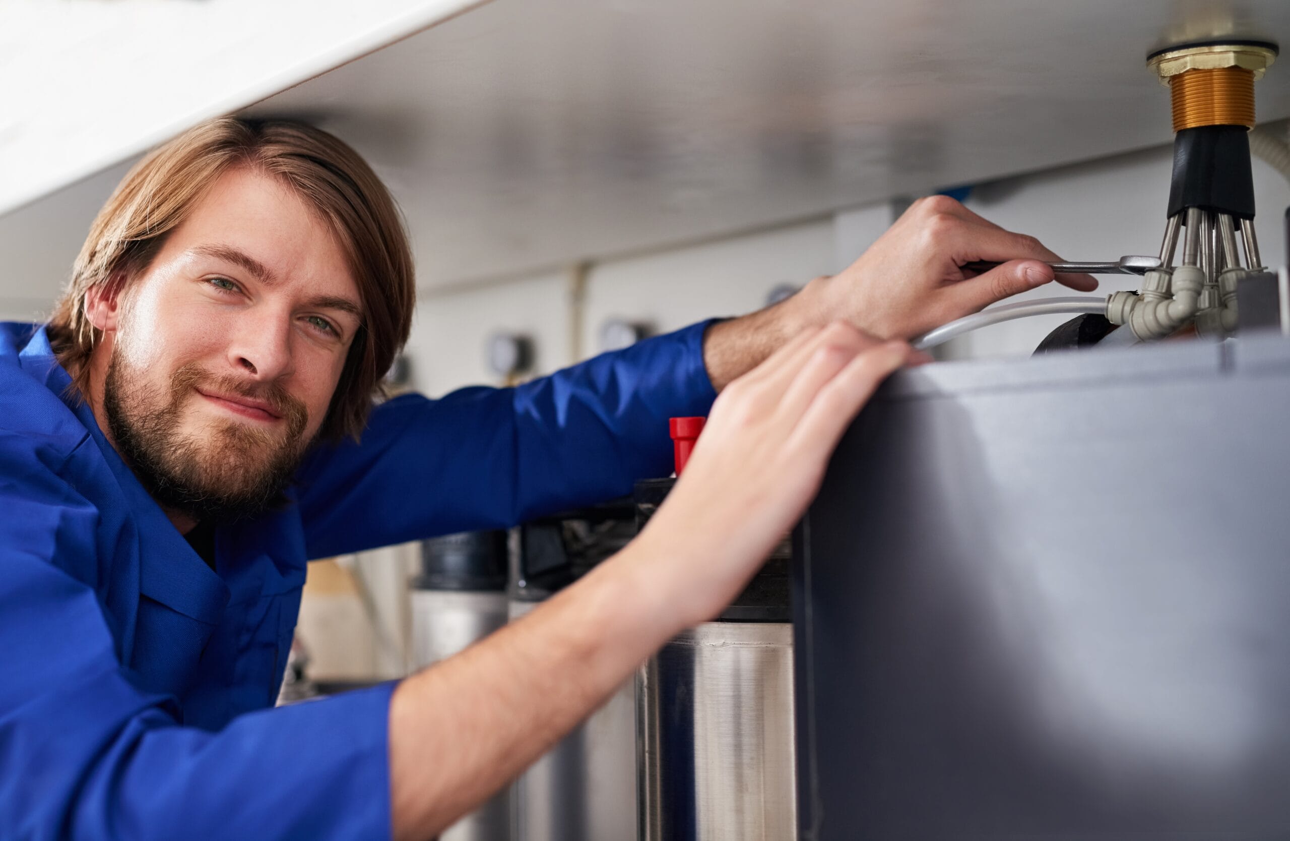 Technician servicing a residential water heater tank in Temple City